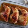 Easy roasted chicken legs with honey on a glass baking dish