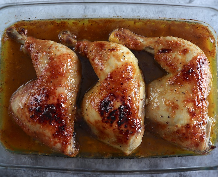 Easy roasted chicken legs with honey on a glass baking dish