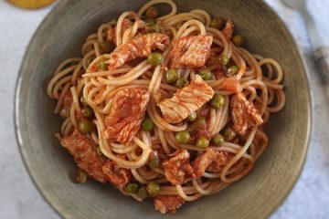 Spaghetti with turkey and peas on a dish bowl