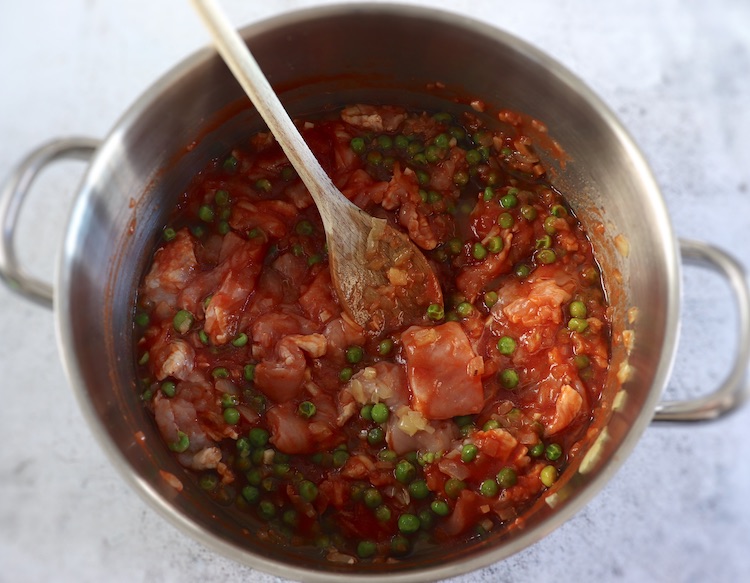 Onion, garlic, olive oil, peas, turkey steaks cut into pieces and tomato pulp in a large saucepan