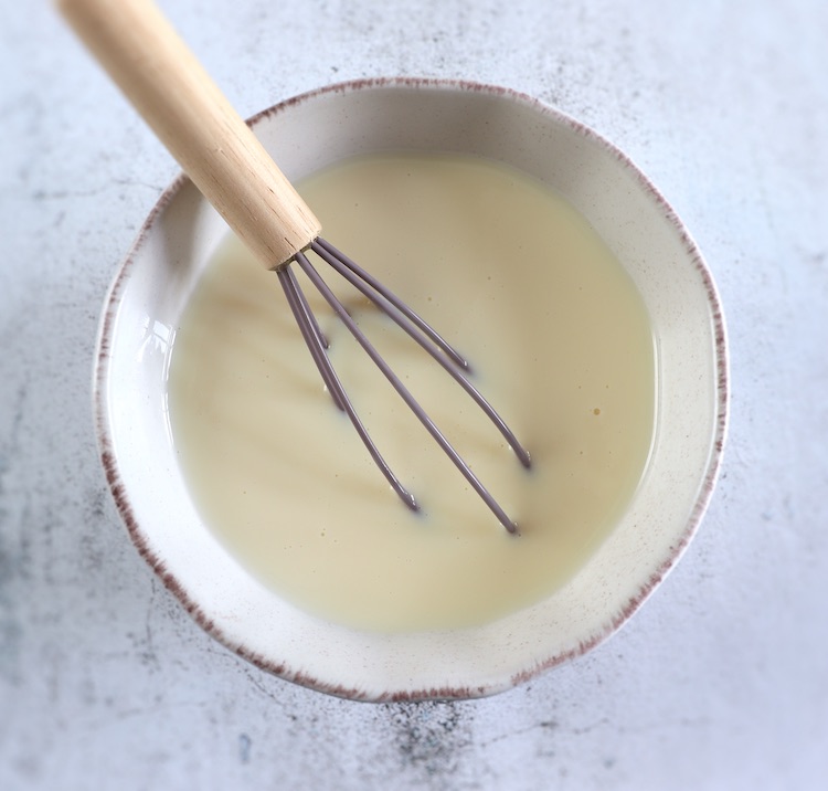 Leite condensado misturado com leite numa tigela