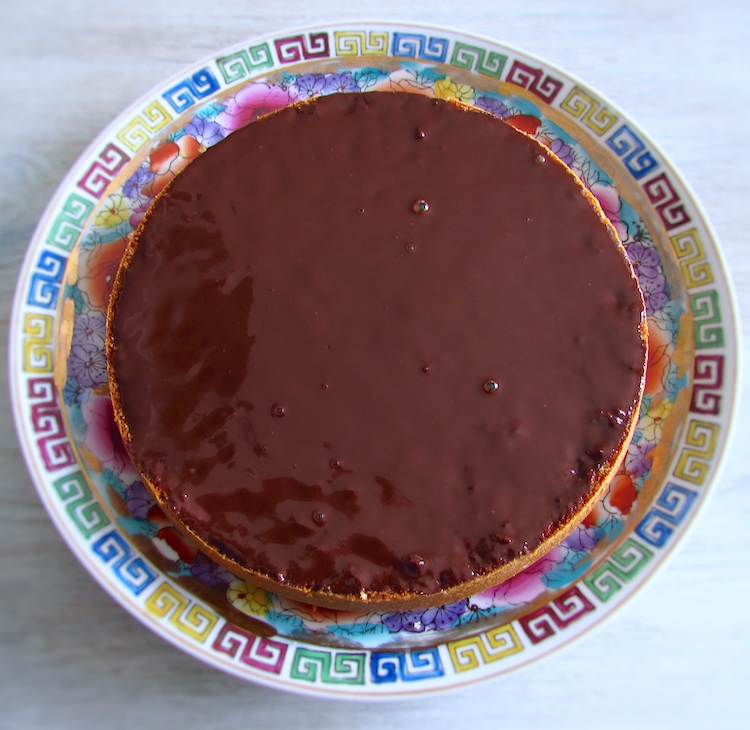Bolo de laranja cortado ao meio na horizontal, recheado com creme de chocolate num prato