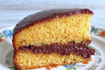 Fatia de bolo de laranja com cobertura de chocolate num prato