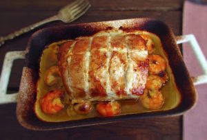 Pork loin in the oven with shrimp on a baking dish