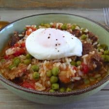 Stewed meat with rice and poached eggs on a dish bowl