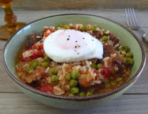 Stewed meat with rice and poached eggs on a dish bowl
