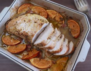 Slices of turkey loin with orange on a baking dish