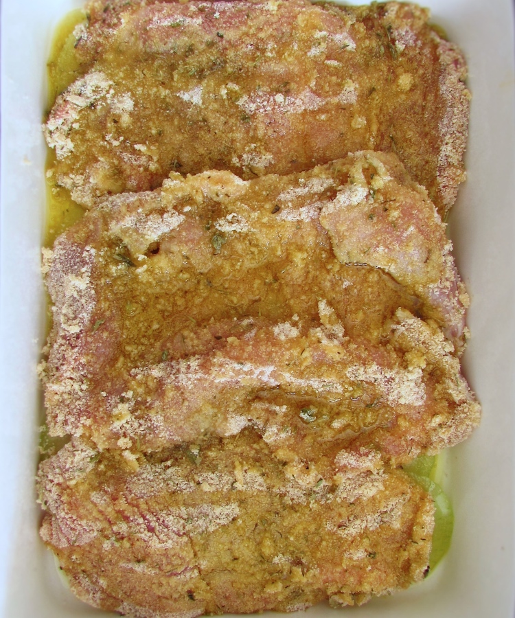 Breaded pork steak with olive oil on a baking dish