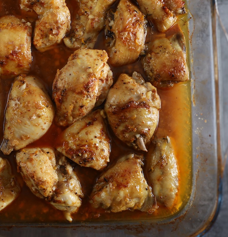 Baked chicken with orange and spices on a glass baking dish