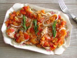 Bifes de peru no forno com tomate numa assadeira