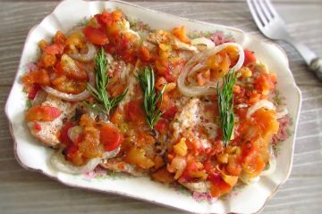 Bifes de peru no forno com tomate numa assadeira