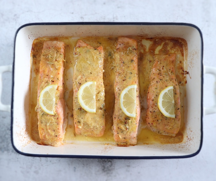 Easy baked salmon with lemon and mustard sauce on a baking dish