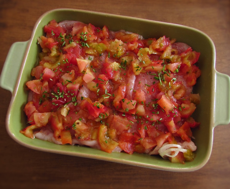 Turkey steaks with tomato on a baking dish