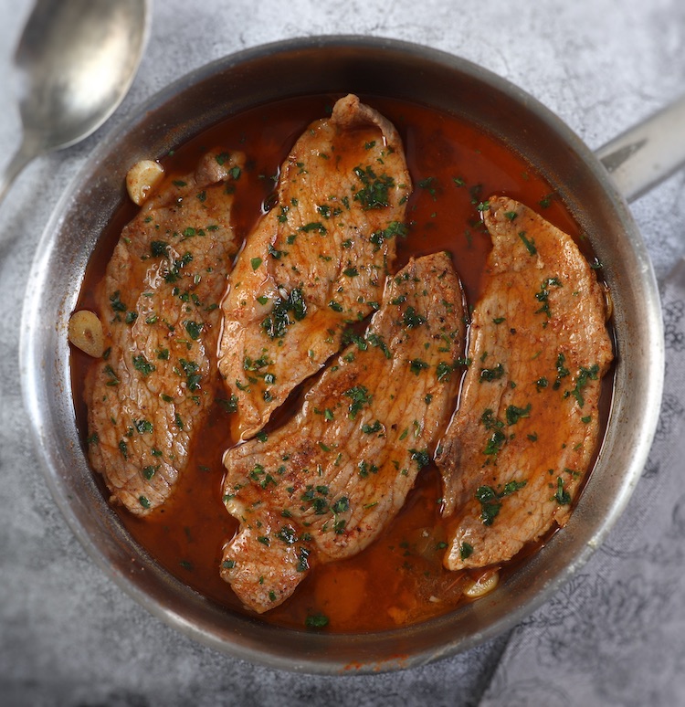 Easy pork steaks with delicious sauce on a frying pan