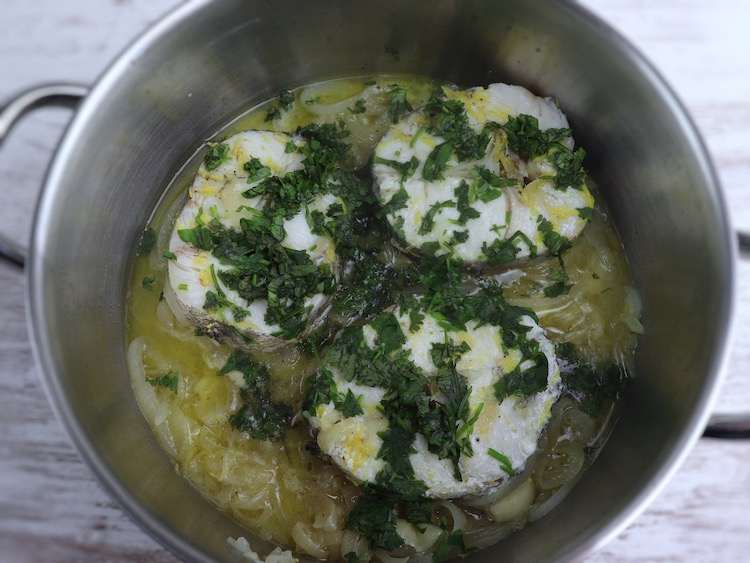 Stewed hake with lemon and coriander on a saucepan