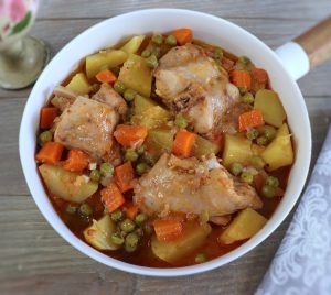 Rabbit stew with potatoes, peas and carrots on a dish bowl