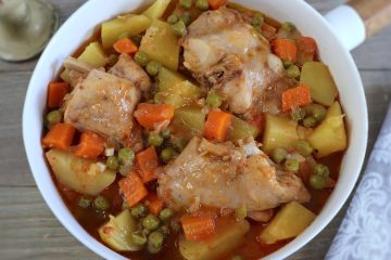 Rabbit stew with potatoes, peas and carrots on a dish bowl