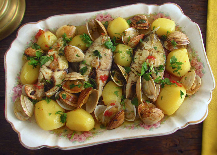 Wreckfish in the oven with clams on a platter
