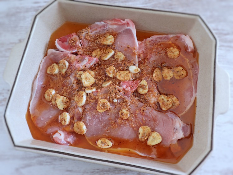 Pork chops on a baking dish seasoned with salt and a delicious sauce