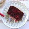 Slice of simple chocolate triple berry cake on a plate