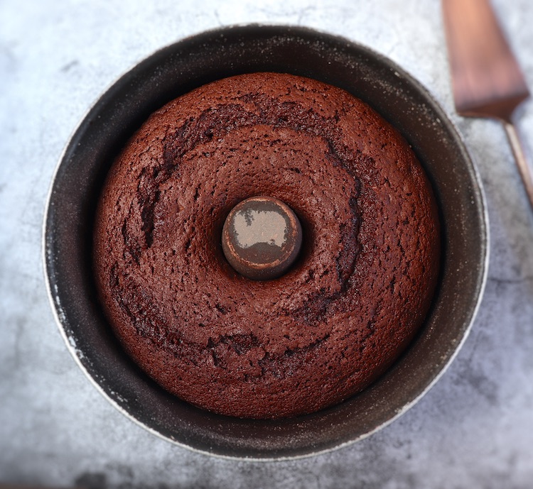 Bolo doce de chocolate numa forma de bolos redonda com furo no meio