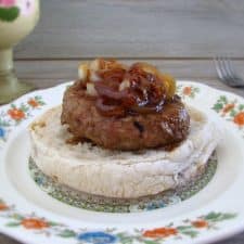 Burger with caramelized onion with a bread slice on a plate
