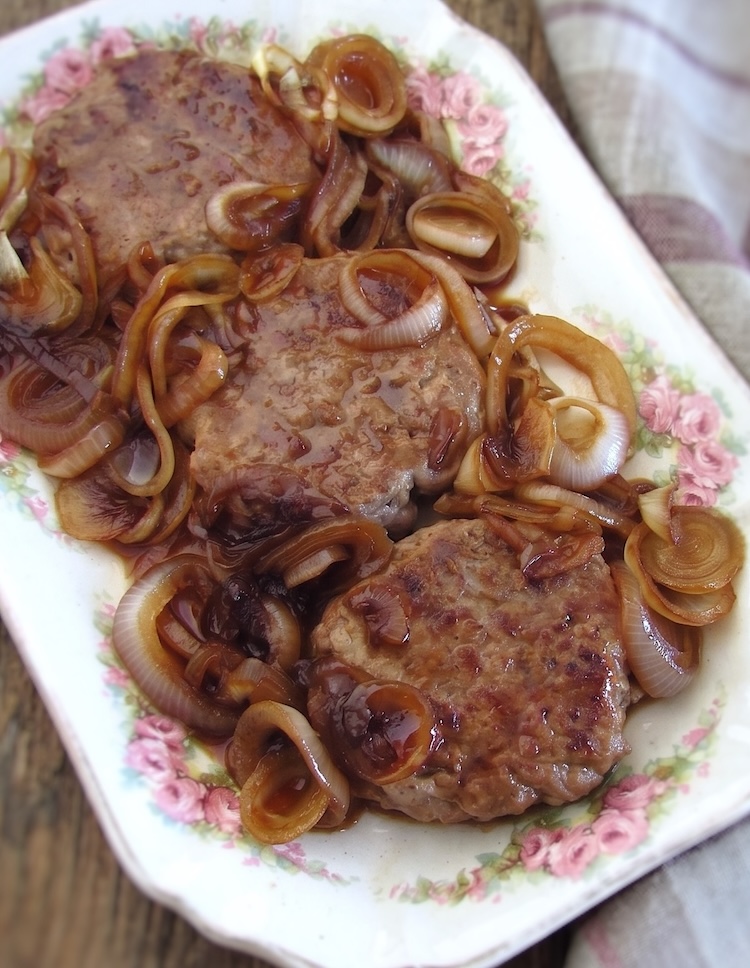 Hambúrgueres caseiros com cebola caramelizada numa travessa