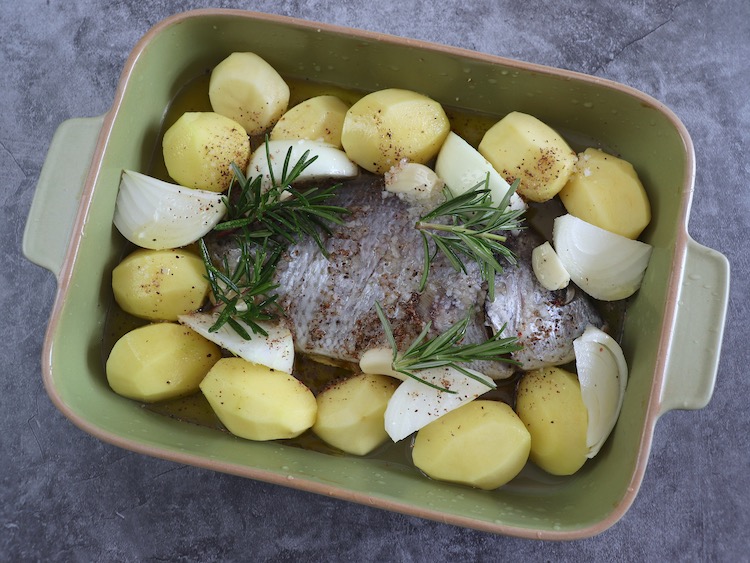 Sea bream with potatoes on a baking dish