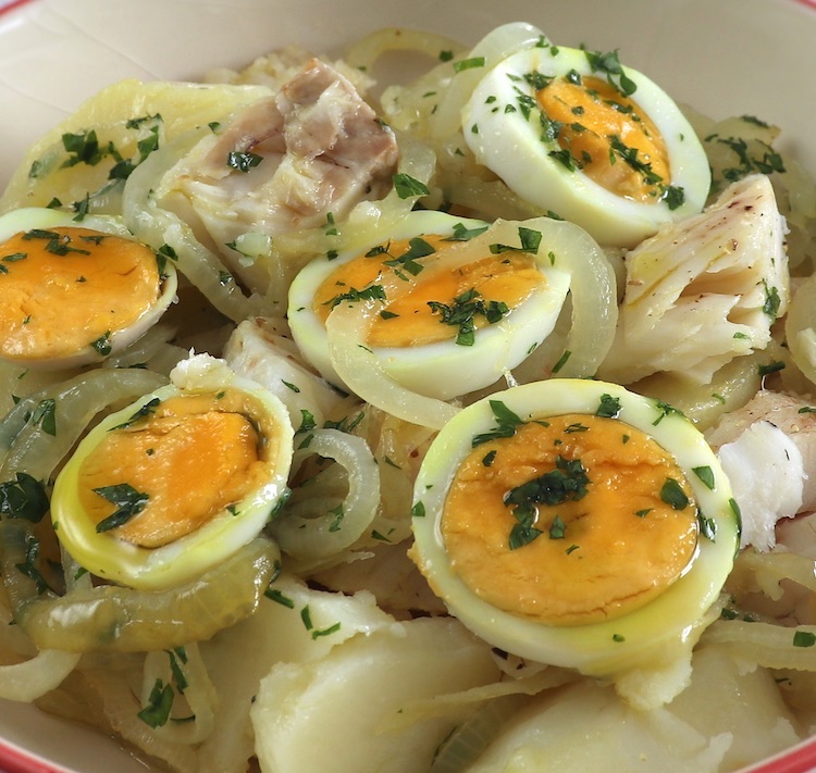 Hake with potatoes and eggs on a dish bowl