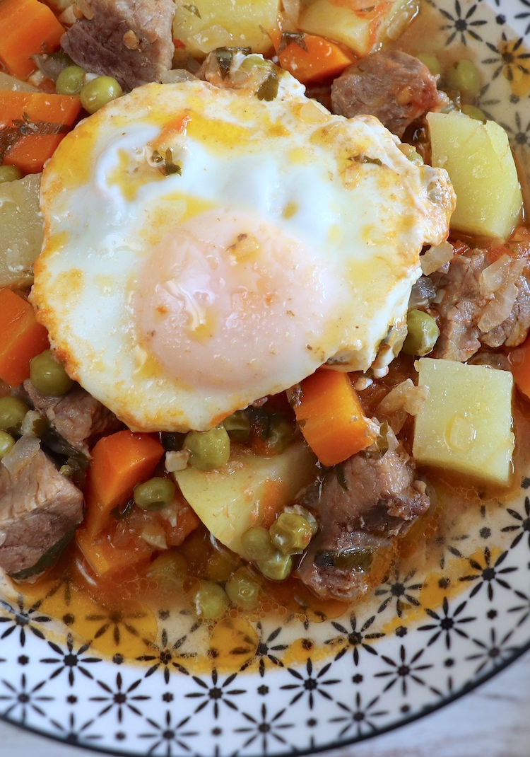 Beef stew with potatoes and poached eggs on a plate