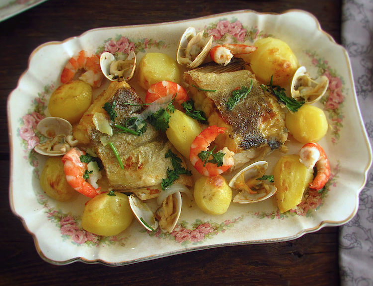 Cod in the oven with shrimp and clams on a platter