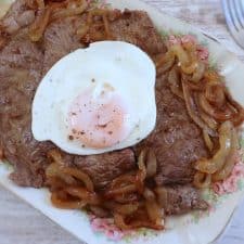 Fried steaks with fried egg on a platter