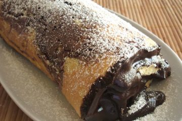 Marble roll cake filled with chocolate on a platter