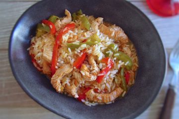 Bifes de peru com pimentos e arroz num prato fundo