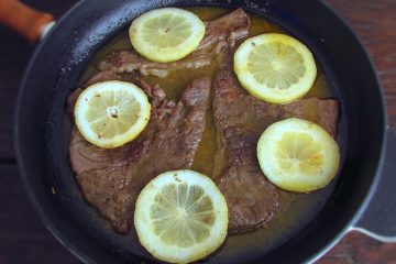 Steaks with lemon and honey on a frying pan