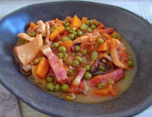 Cuttlefish with peas and carrots on a dish bowl