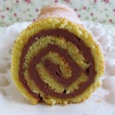 Orange roll cake filled with chocolate on a platter
