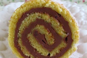 Orange roll cake filled with chocolate on a platter
