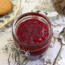 Strawberry jam in a glass jar with crackers