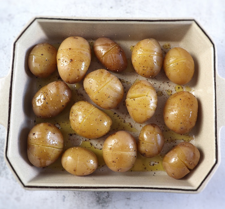 Pommes de terre assaisonnées de poivre et d'huile d'olive sur un plat allant au four