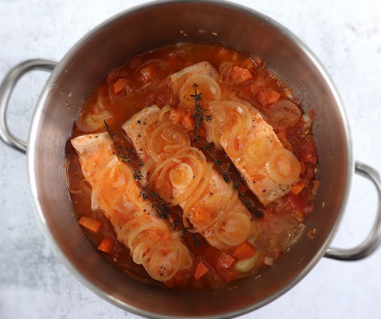 Salmon in tomato sauce on a large saucepan