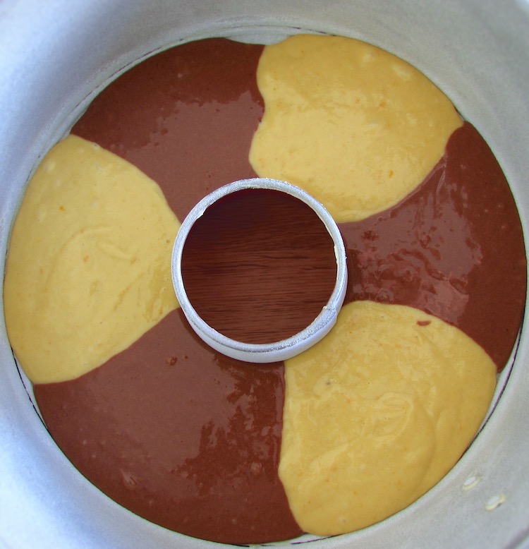 Massa de bolo mármore de chocolate e laranja numa forma de bolos redonda com furo no meio