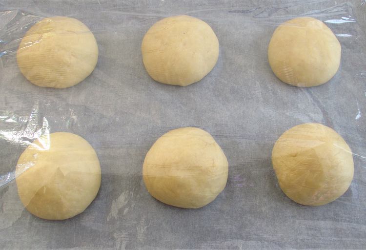 Milk bread dough filled with chocolate divided in six covered with cling film