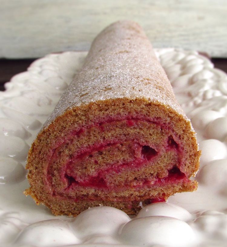 Cinnamon roll cake filled with strawberry cream on a platter