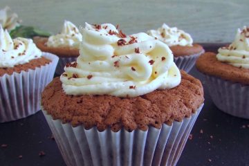 Chocolate muffins with cream on a wooden table