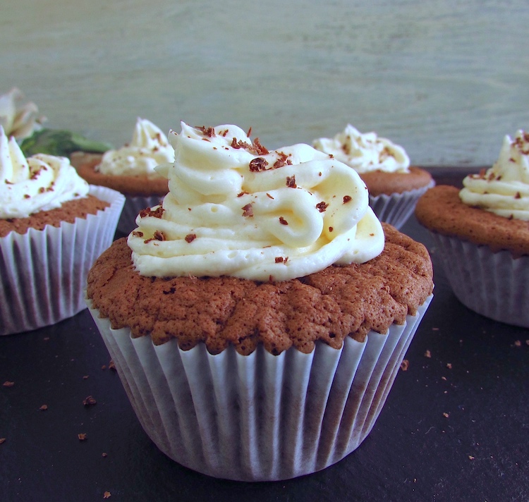 Chocolate muffins with cream on a wooden table