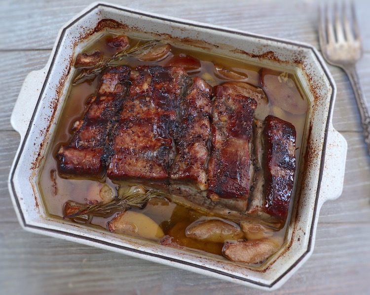 Baked pork ribs with apple on a baking dish