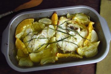Ling fish in the oven with orange and lemon on a baking dish