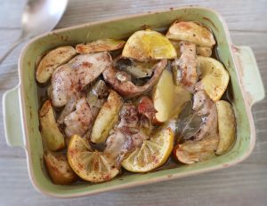Baked rabbit with apple and lemon on a baking dish
