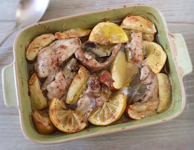 Rabbit in the oven with apple and lemon on a baking dish